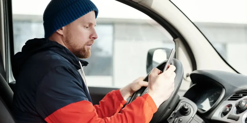 Man in Red and Black Jacket Driving Car